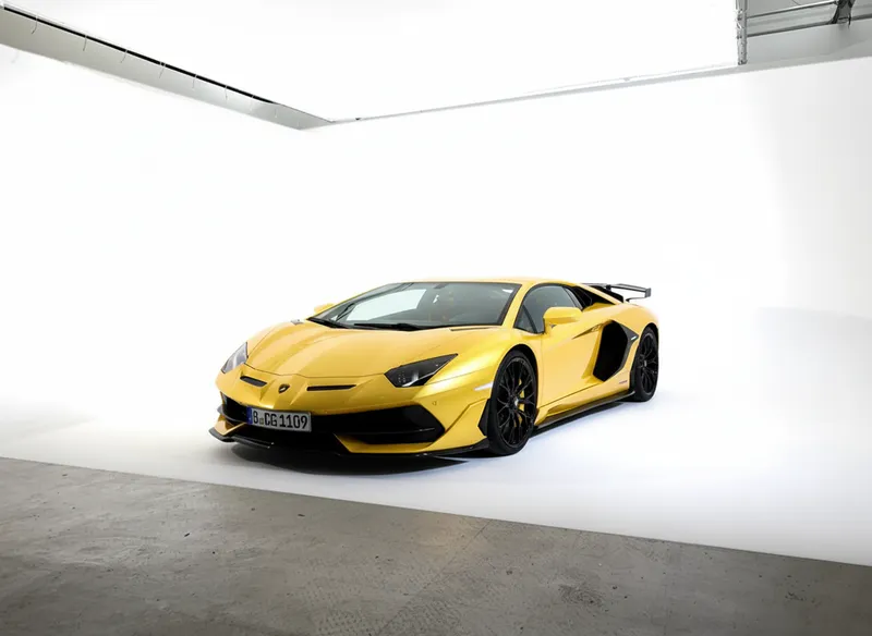 Gelber Sportwagen in weißer Hohlkehle eines Fotostudios, Fahrzeug-Shooting