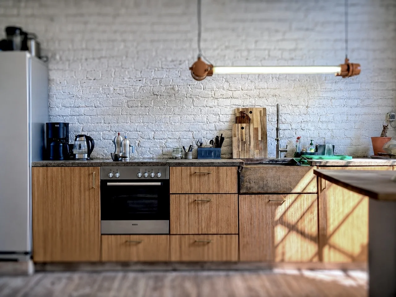Helles Fotostudio mit großen Sprossenfenstern, Topflanze, LED-Lichttechnik, Stativ und Sitzmöbel