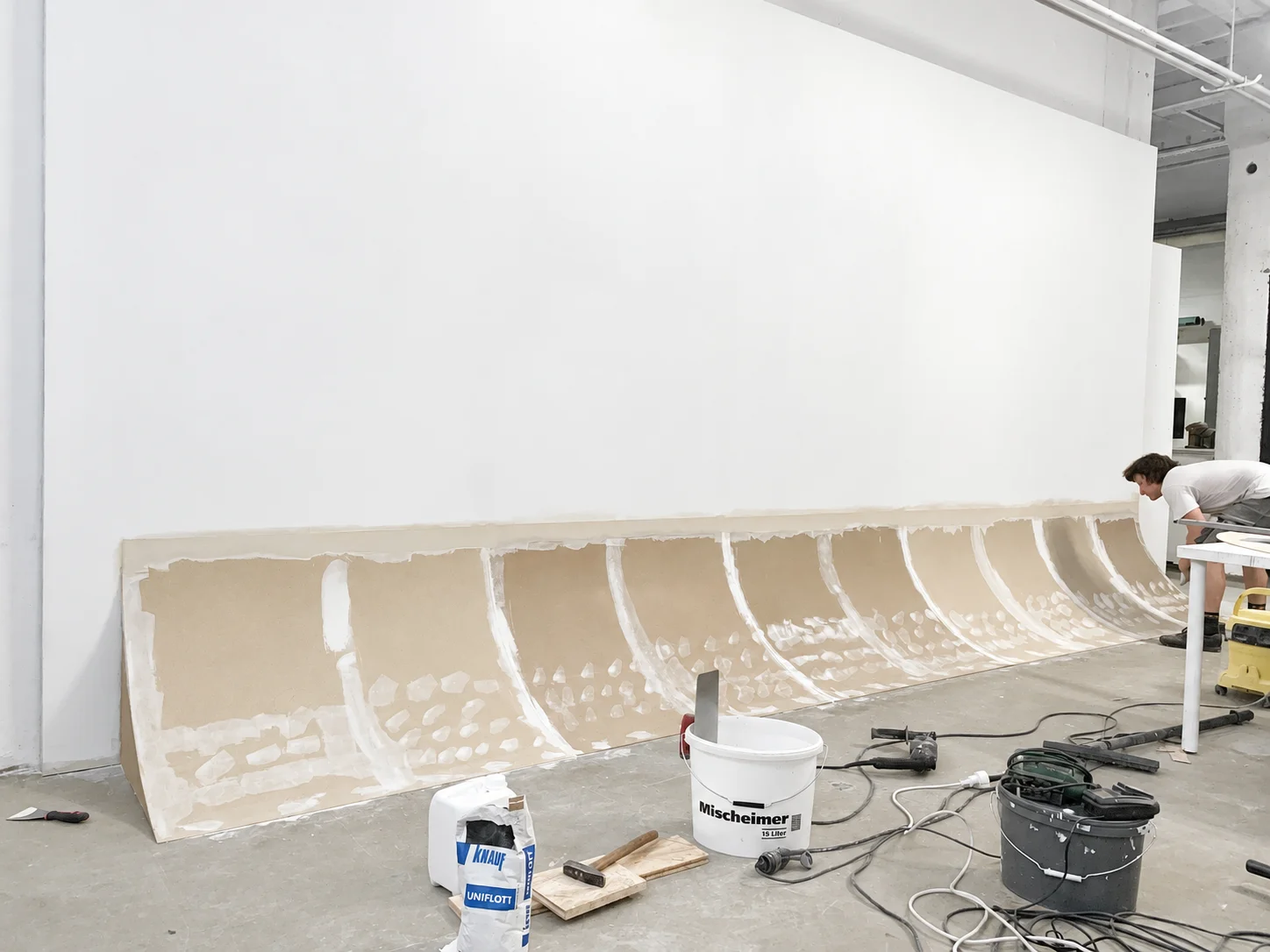 Baustelle mit Rigipsplatten, mit Werkzeugen für weiße Hohlkehle in Fotostudio.